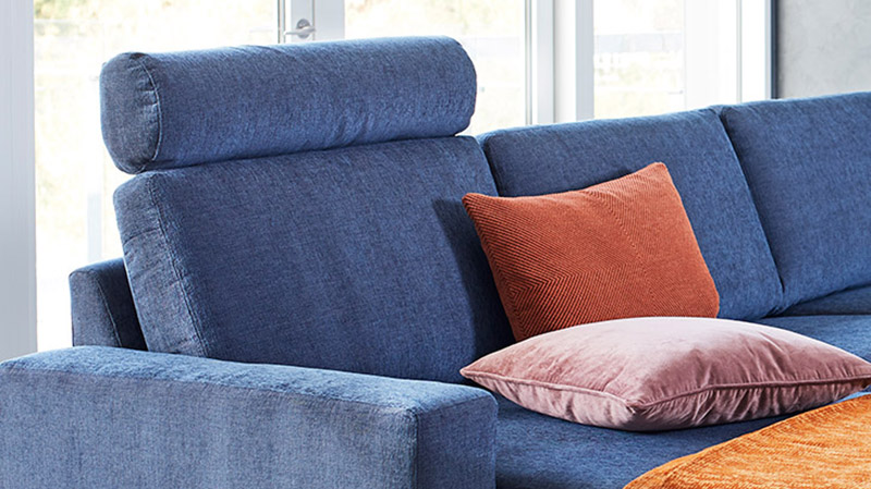 Sofa i blåt stof med nakkestøtte